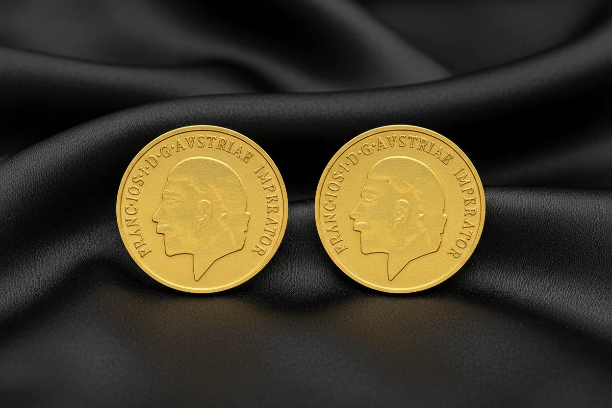 Two gold coins with a profile of a person on a white background