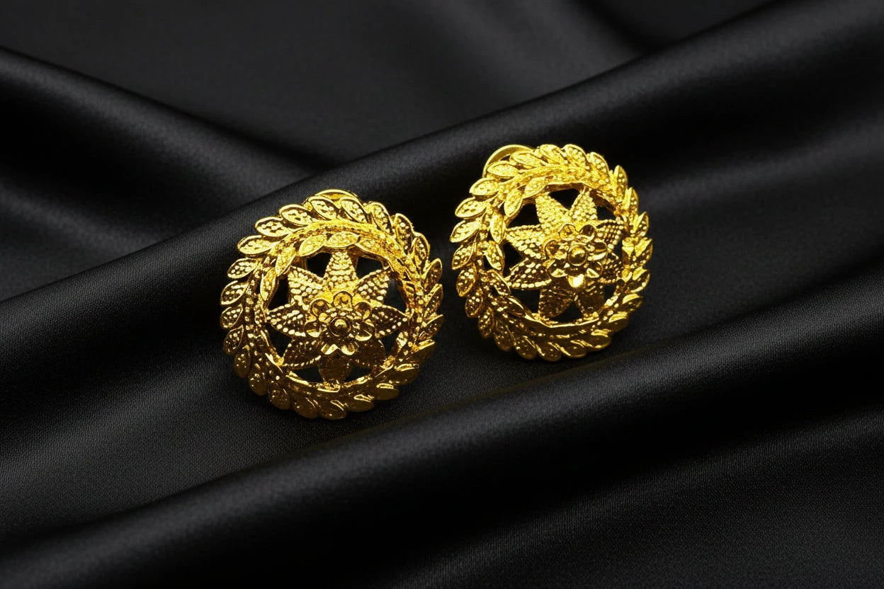 Pair of gold circle floral earrings on a black background