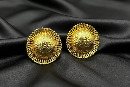 Pair of circle gold earrings on a black background