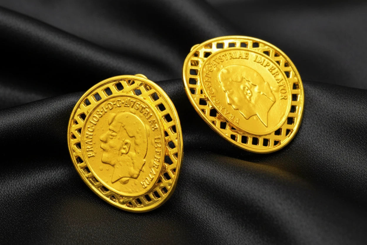 Two gold coins with a portrait on a dark surface