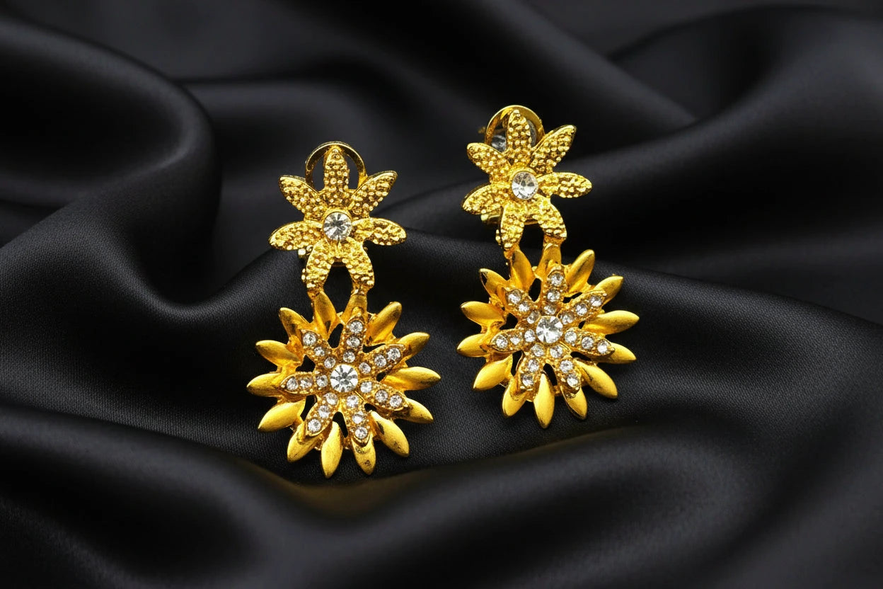 Gold floral earrings with rhinestones on a black background